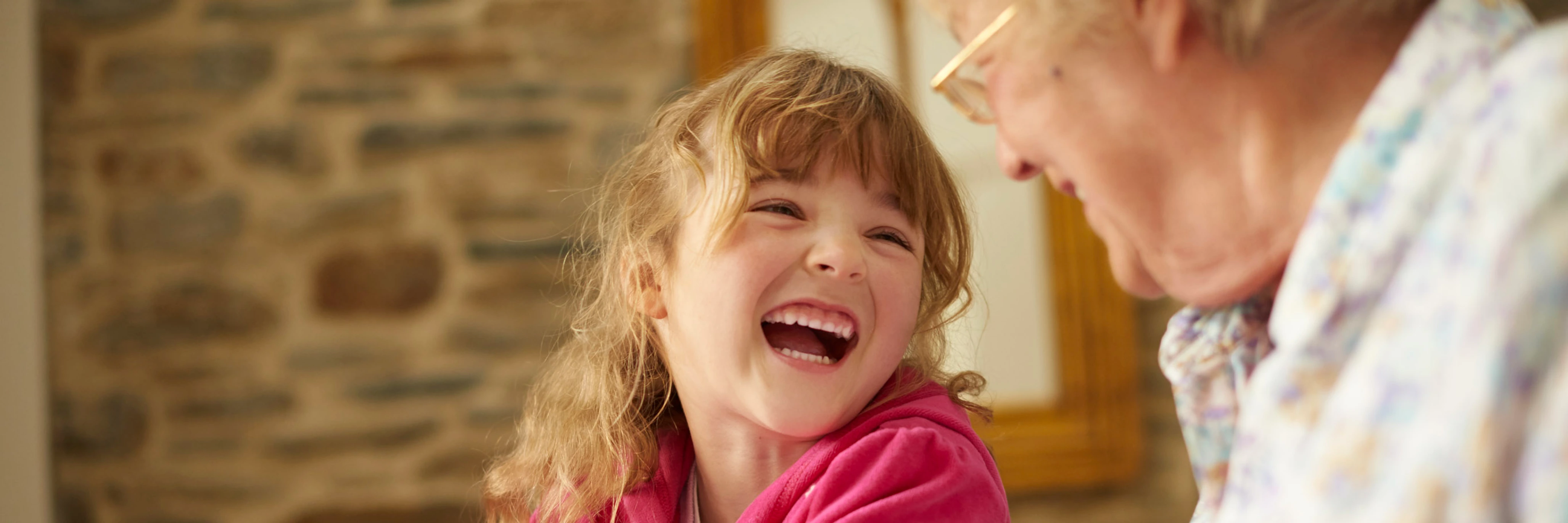 A young child and older person laughing