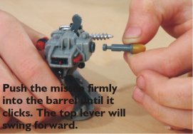 Push the missile firmly into the barrel until it clicks. The top lever will swing forward. Push the missile firmly into the barrel until it clicks. The top lever will swing forward.